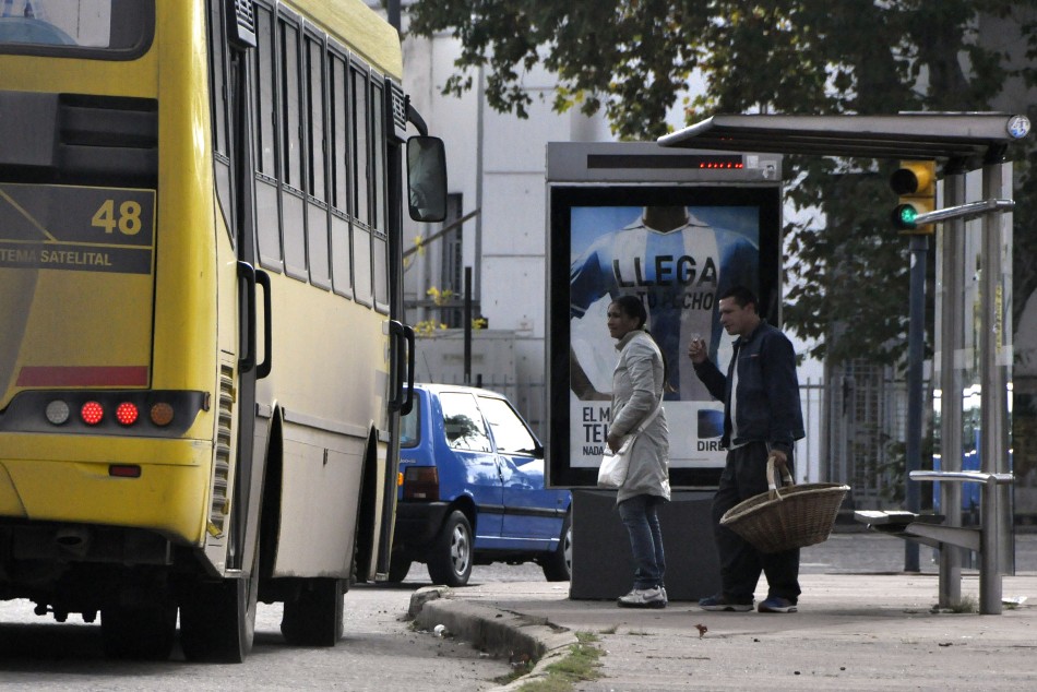 2449 | Gente tomando colectivo en refugio - Dir. Gral. de Comunicación Social (Franco Trovato)